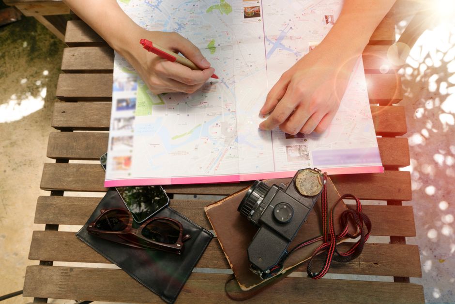 Viaggiatore che confronta un itinerario generato dall'AI con una guida turistica tradizionale per assicurarsi dell'accuratezza