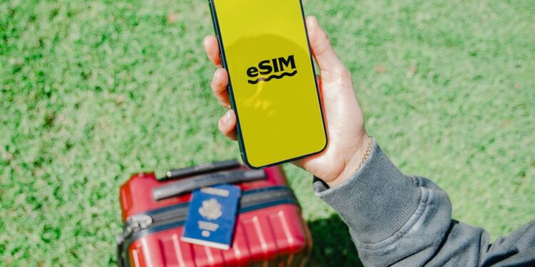 Un viaggiatore confronta una travel SIM fisica con un QR code eSIM su uno smartphone.
