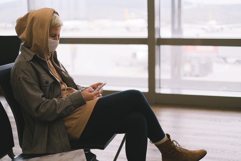 Viaggiatrice in un aeroporto indossa una giacca versatile per diverse stagioni