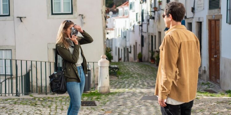 Un viaggiatore fotografa una strada pittoresca in una città europea.