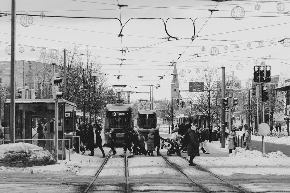 Scena urbana con tram e pedoni in una via trafficata di una città europea