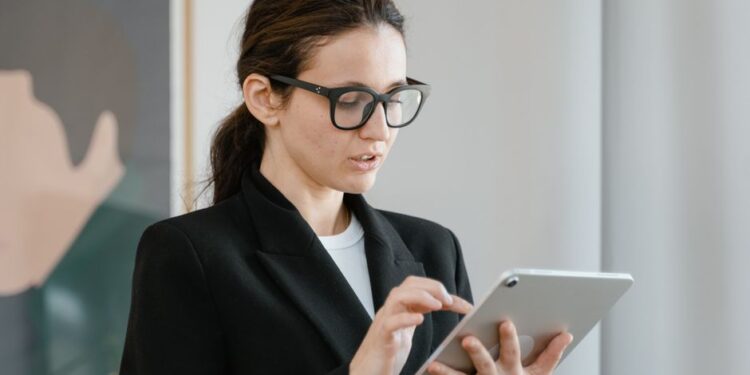 Donna sorridente che confronta offerte di piani mobili su un tablet, circondata da icone di telefonia.