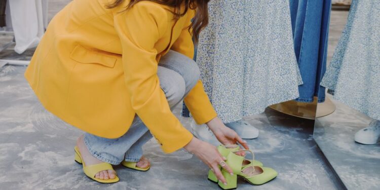 Donna prova eleganti scarpe da città in una boutique italiana, con un'ampia scelta in sottofondo