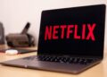 Жінка перемикається від роботи до перегляду фільму на одному ноутбуці, ілюструючи розмиті цифрові межі.