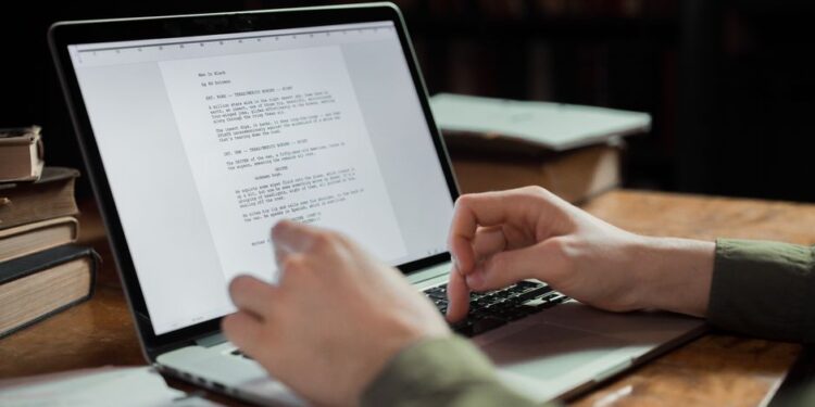 Osoba editující text vygenerovaný umělou inteligencí na notebooku, zdůrazňující lidskou kontrolu nad AI.
