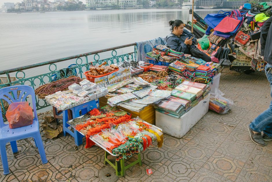 Bancarella di souvenir generici, come calamite e portachiavi con nomi di città, in un mercato.