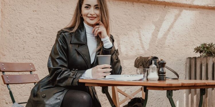 Žena v elegantním smart casual oblečení sedící v útulné kavárně s kávou a knihou.